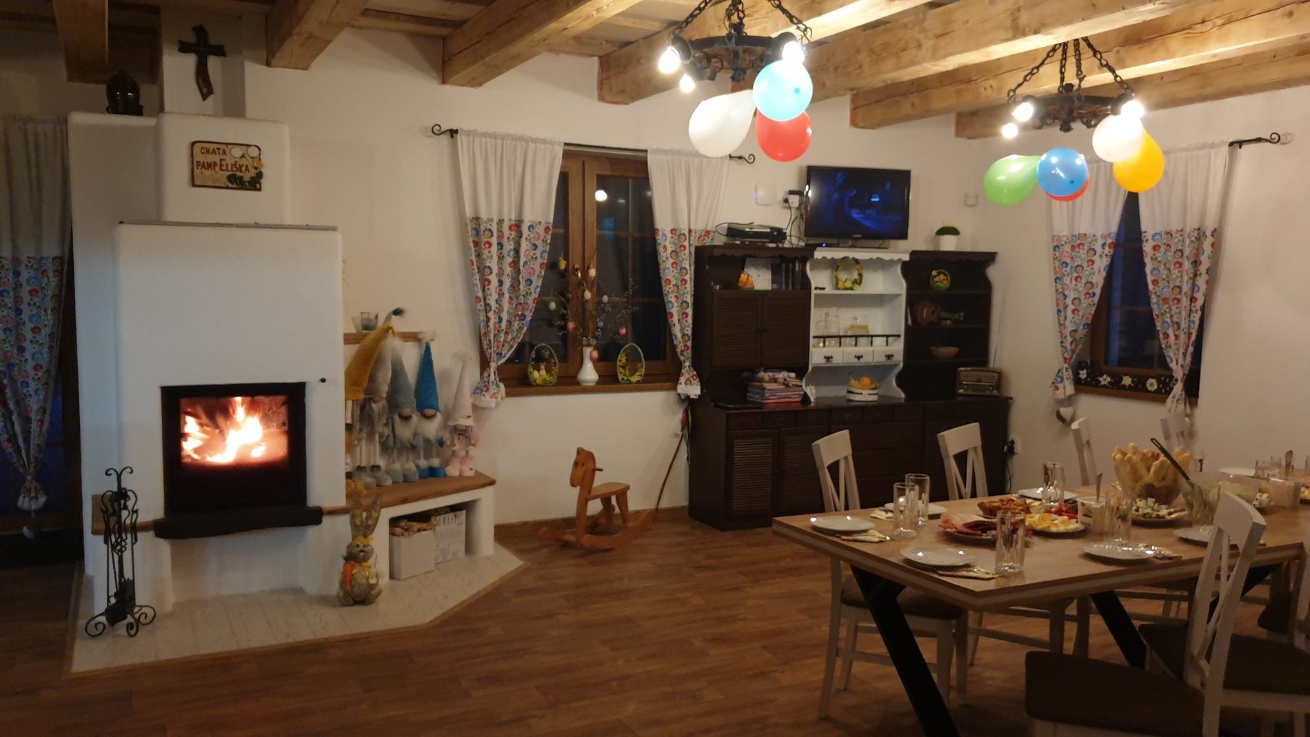 Útulný interiér Chaty Pampeliška s krbom a jedálenským stolom