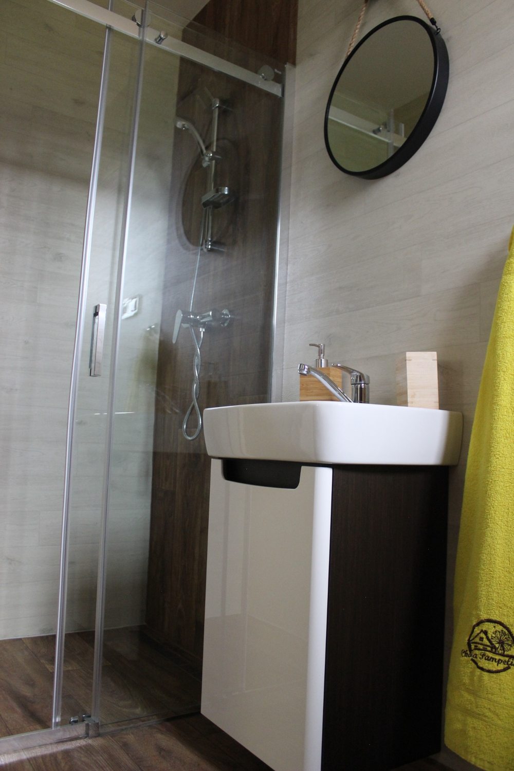 Detail kúpeľne so sprchovacím kútom a umývadlom